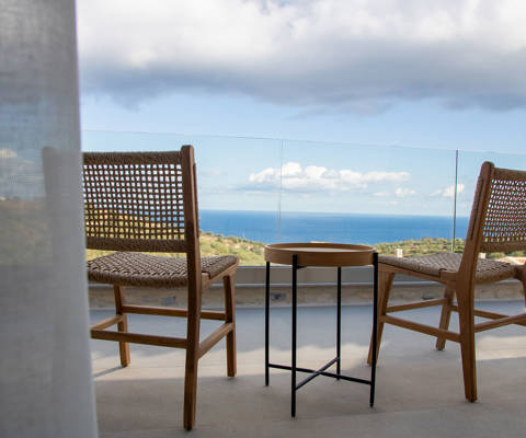 Outdoor area with seating at the edge of the veranda, offering stunning view, close-up shot