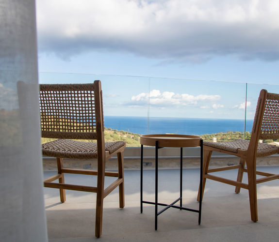 Outdoor area with seating at the edge of the veranda, offering stunning view, close-up shot