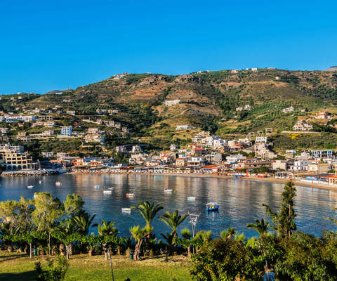 Panoramic view of Agia Pelagia bay and village in Crete, with hills and nature in the background