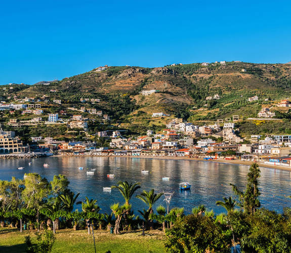 Panoramic view of Agia Pelagia bay and village in Crete, with hills and nature in the background