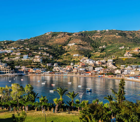 Panoramic view of Agia Pelagia bay and village in Crete, with hills and nature in the background