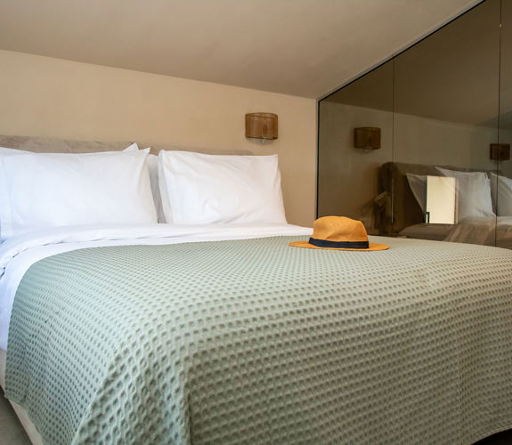 Cozy loft bedroom with double bed and bathroom with mirrored glass walls