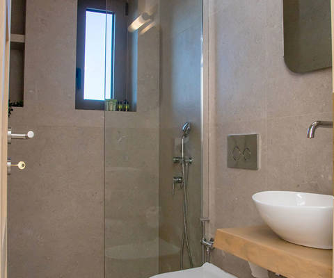 Bathroom interior, Comfortable shower with glass partition, sink with mirror and space with neatly placed towels.