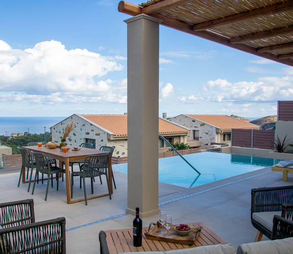 Outdoor pool area, having a dining table, a comfortable siting room, sunbeds and amazing view