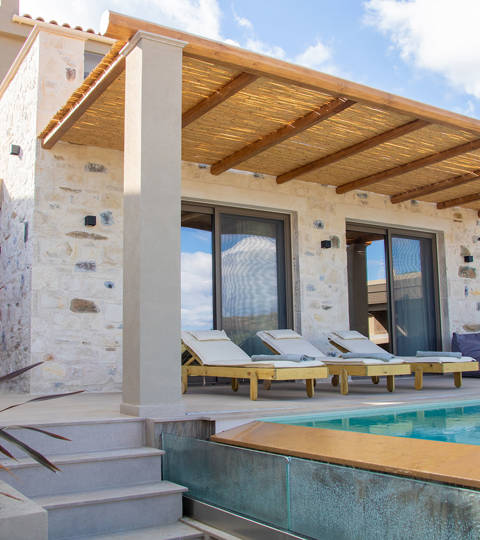 Outdoor pool area, having a comfortable siting room and sunbeds, side view