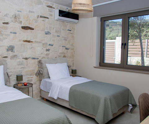 Comfortable bedroom with two single beds, a large window, air conditioning and a desk