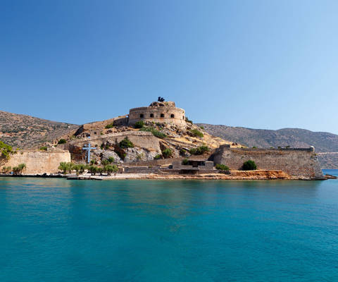 View of Spinalonga island fortress in Crete, surrounded by blue waters