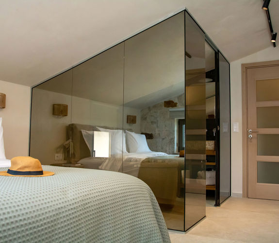 Modern bedroom with double bed, glass-walled shower and minimalistic decor