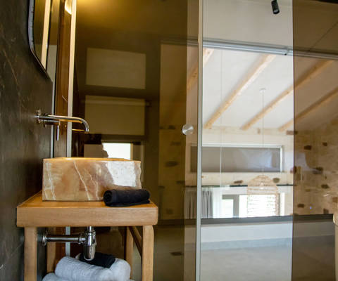 Elegant bathroom with stone sink and glass wall in the loft area