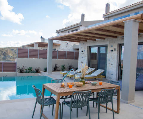 Outdoor pool area, having a dining table and sunbeds, side view