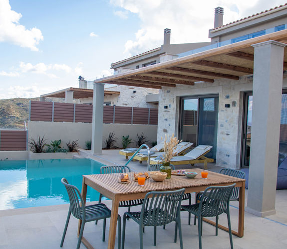 Outdoor pool area, having a dining table and sunbeds, side view