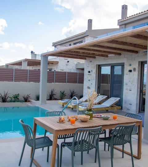Outdoor pool area, having a dining table and sunbeds, side view