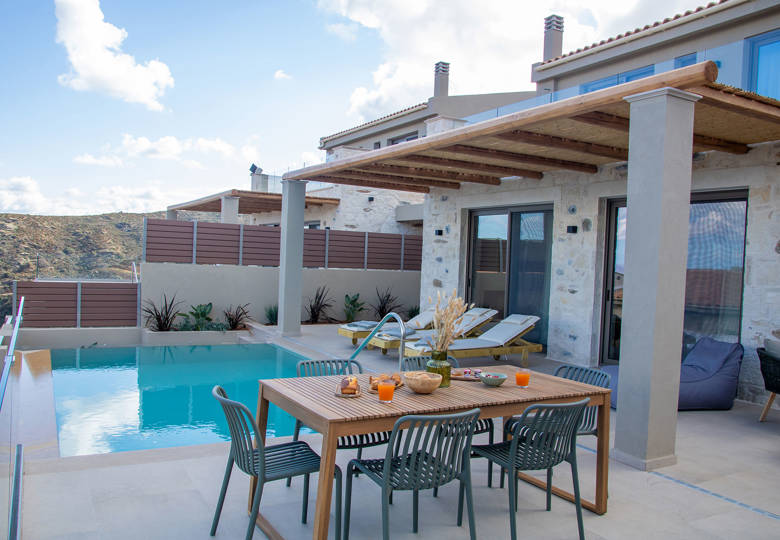 Outdoor pool area, having a dining table and sunbeds, side view