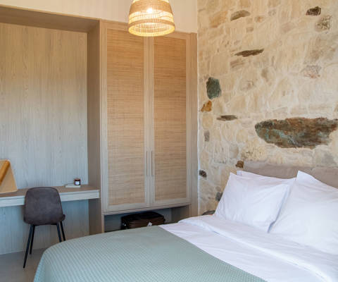 Bedroom interior with double bed and office space next to the wardrobe.