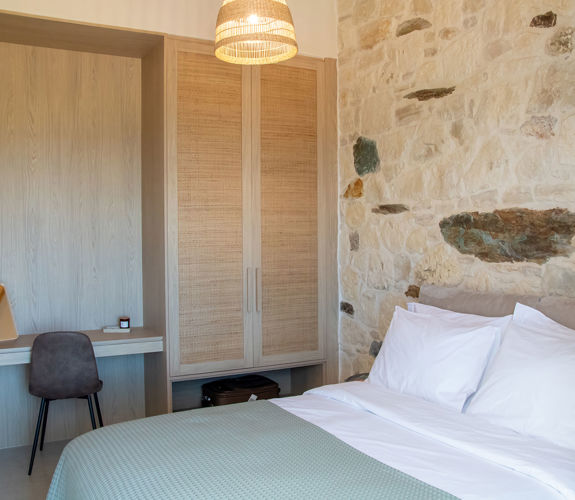 Bedroom interior with double bed and office space next to the wardrobe.